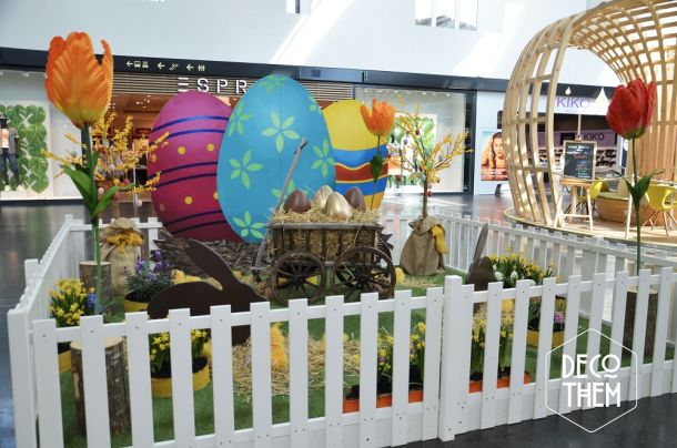 Décoration pâques, barrières blanche, tulipes géantes, gazon, parterre fleuri, charrettes avec des gros œufs, forsythia en fleurs, œufs de pâques géants, poussins , paille