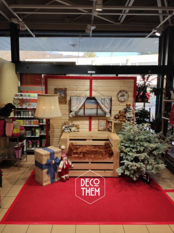 Stand photo St-Nicolas / Père-Noël, tapis rouge, canapé palette, fourrure, sapins illuminé, paroi en bois, luminaires, fenêtre hivernale